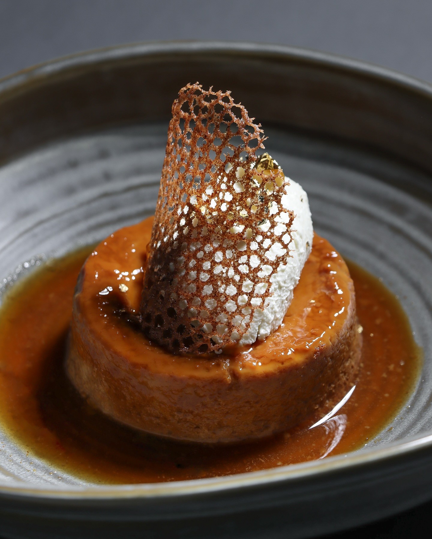 Freshly baked Margherita pizza with melted cheese, tomato sauce, and basil leaves, held by a person’s hand.